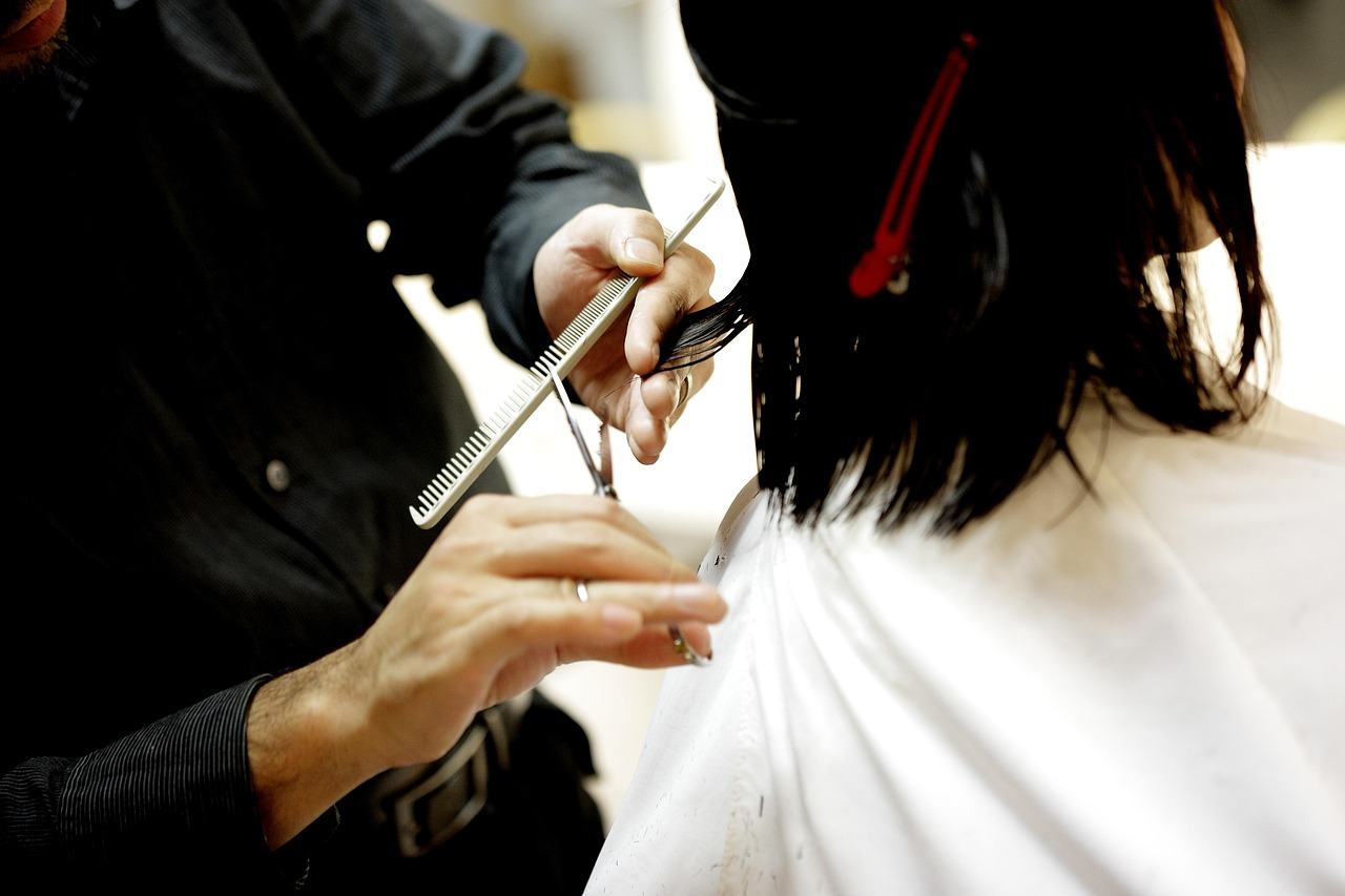 Coiffeur réalisant une coupe de cheveux au ciseau et au peigne